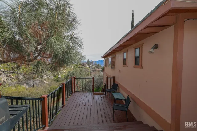 a view of a balcony with wooden floor and bench