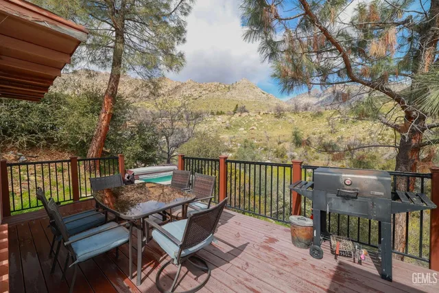 a view of a patio with table and chairs with wooden floor and fence