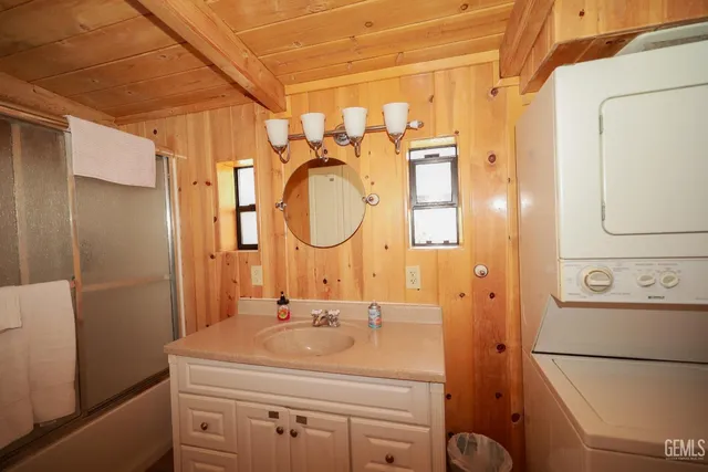 a view of a patio with table and chairs next to a yard with large trees