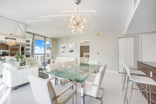 a view of a dining room with furniture a chandelier and wooden floor