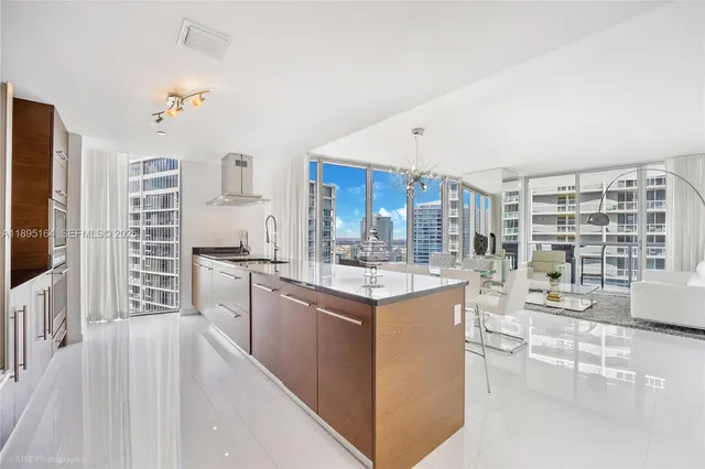 a kitchen with kitchen island granite countertop a sink stove and cabinets