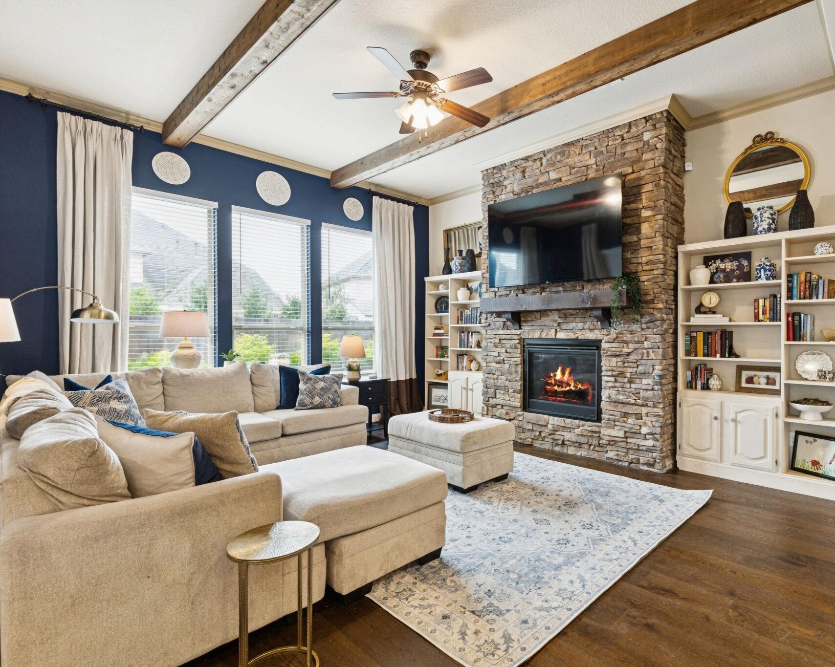 1118 Fragile Sail Court Katy, TX 77494 - Photo 4 of 36 Relax on the main living room, under rustic exposed wood beams by the floor-to-ceiling stone gas log fireplace.