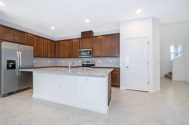 a kitchen with stainless steel appliances granite countertop a refrigerator sink and cabinets