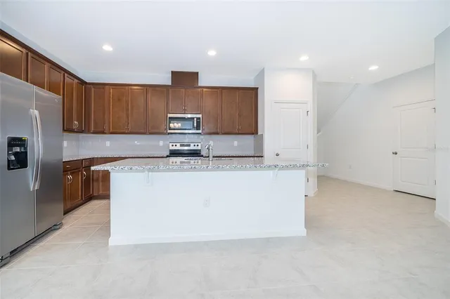 a kitchen with kitchen island a sink a stove a refrigerator and a center island