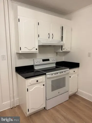 a kitchen with granite countertop white cabinets and white appliances