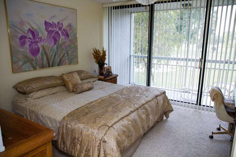 6169 Balboa Circle, Unit 203 Boca Raton, FL 33433 - Photo 6 of 19 a bedroom with a bed and a painting on the wall