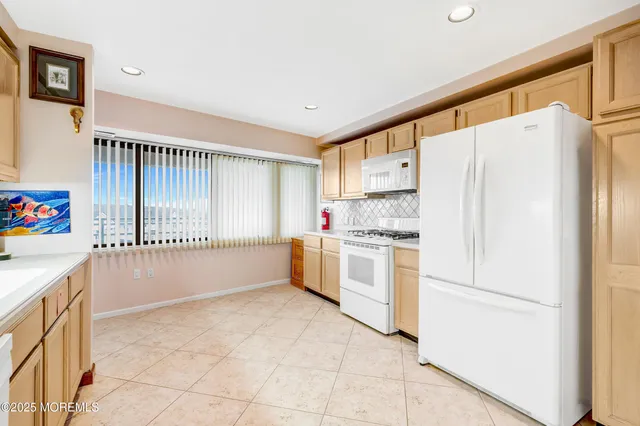 a kitchen with granite countertop white cabinets and white appliances