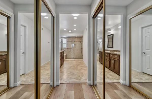 a view of a hallway with wooden floor and a living room