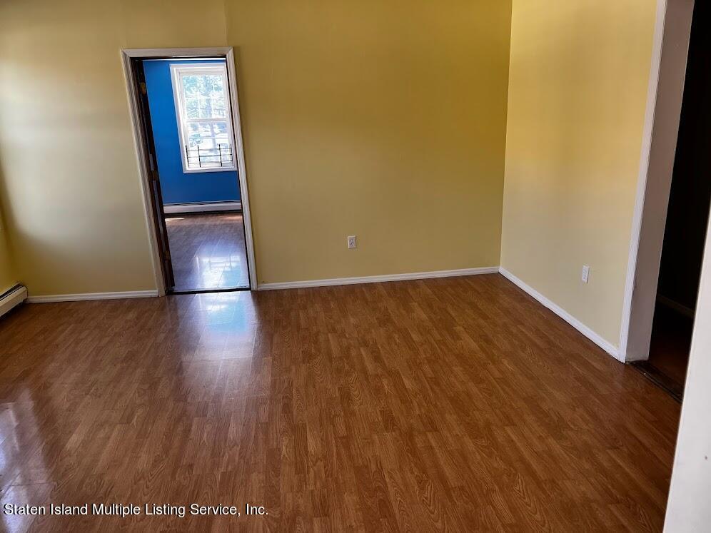 1641 Castleton Avenue Staten Island, NY 10302 - Photo 11 of 15 an empty room with wooden floor and hallway