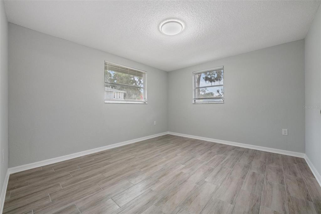 7806 Butler Avenue Hudson, FL 34667 - Photo 11 of 31 an empty room with wooden floor and windows