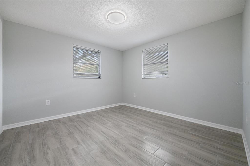 7806 Butler Avenue Hudson, FL 34667 - Photo 13 of 31 an empty room with wooden floor and windows