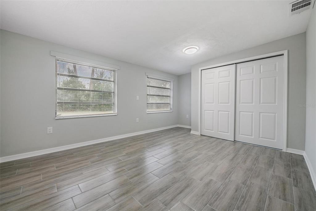 7806 Butler Avenue Hudson, FL 34667 - Photo 15 of 31 a view of an empty room with wooden floor and a window
