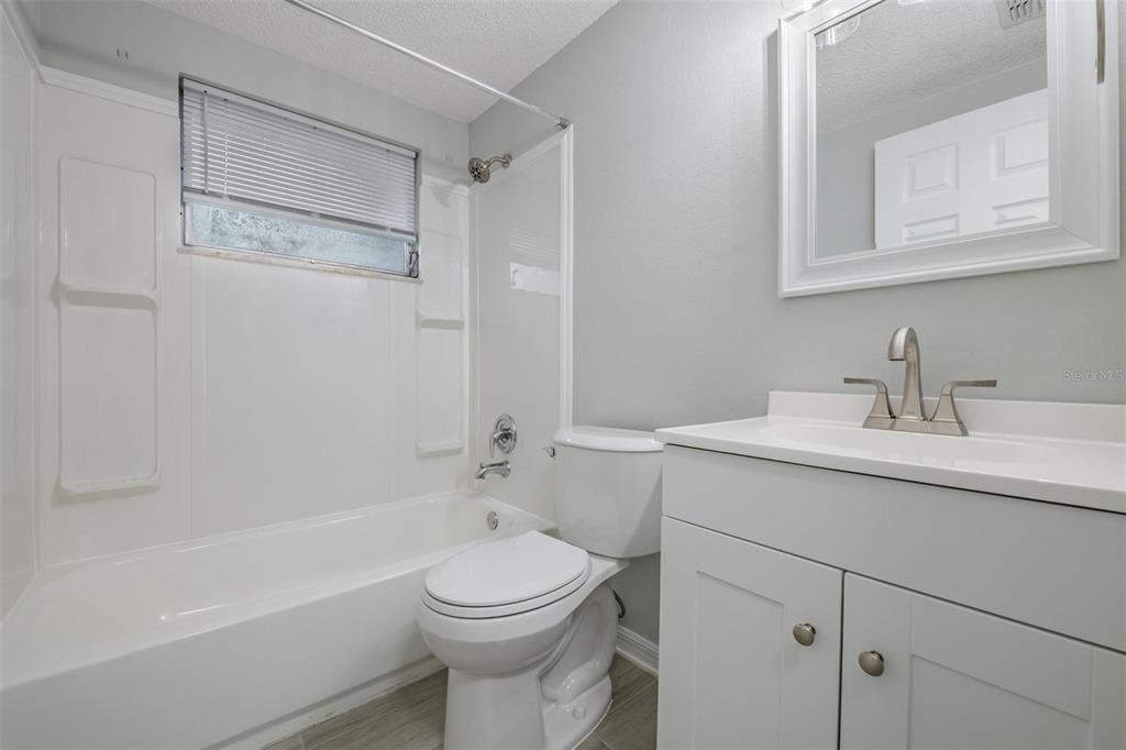 7806 Butler Avenue Hudson, FL 34667 - Photo 16 of 31 a bathroom with a toilet a sink a mirror a bathtub and vanity