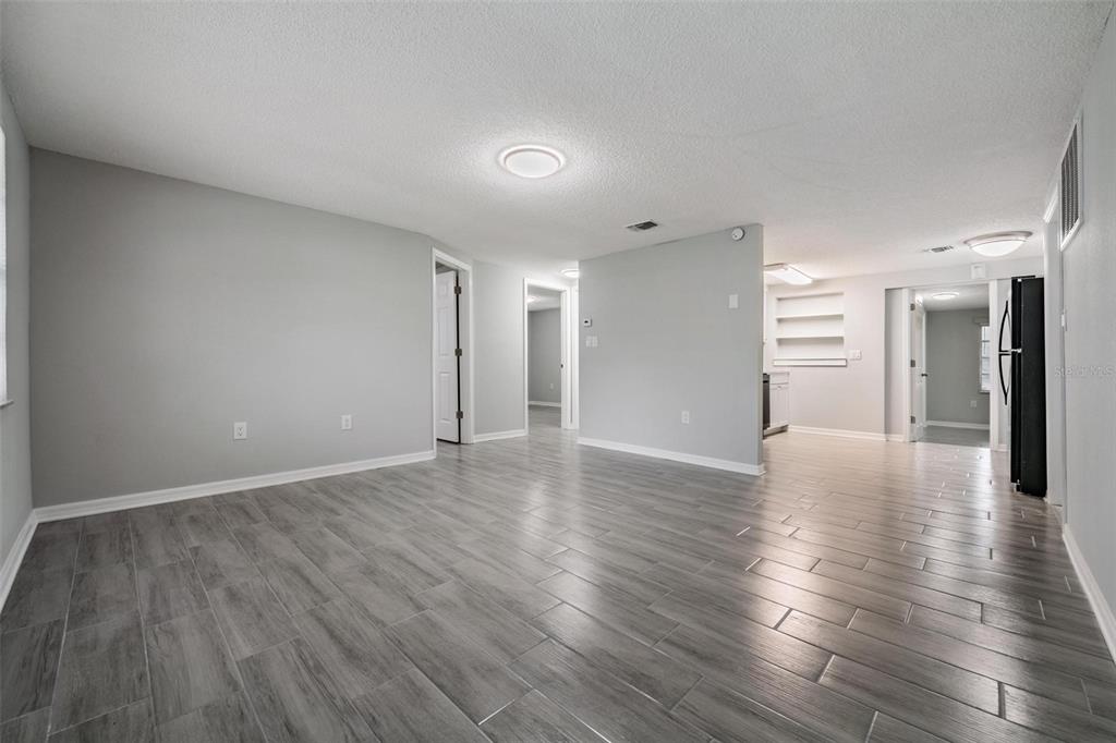 7806 Butler Avenue Hudson, FL 34667 - Photo 3 of 31 a view of a livingroom with wooden floor and a kitchen