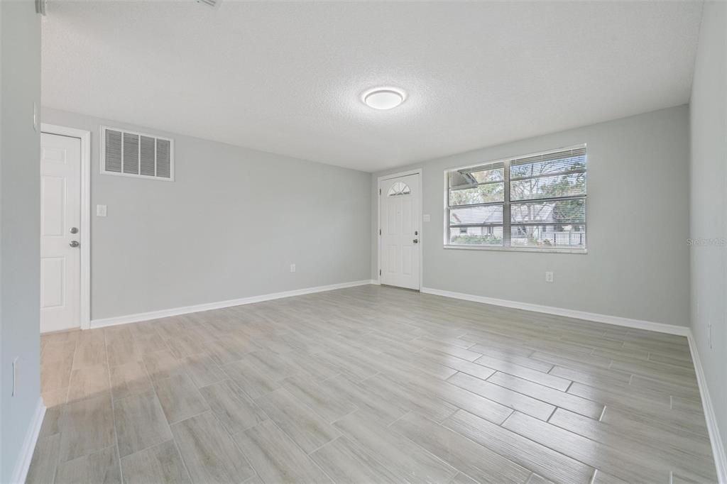 7806 Butler Avenue Hudson, FL 34667 - Photo 5 of 31 an empty room with wooden floor and windows