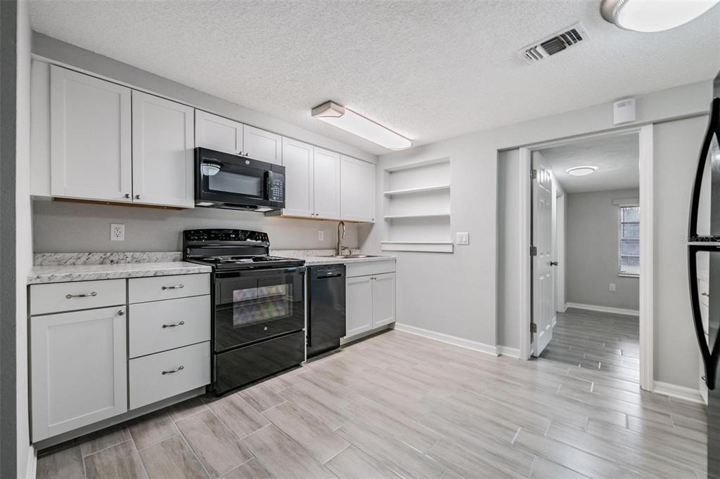 7806 Butler Avenue Hudson, FL 34667 - Photo 7 of 31 a kitchen with cabinets stainless steel appliances and wooden floor