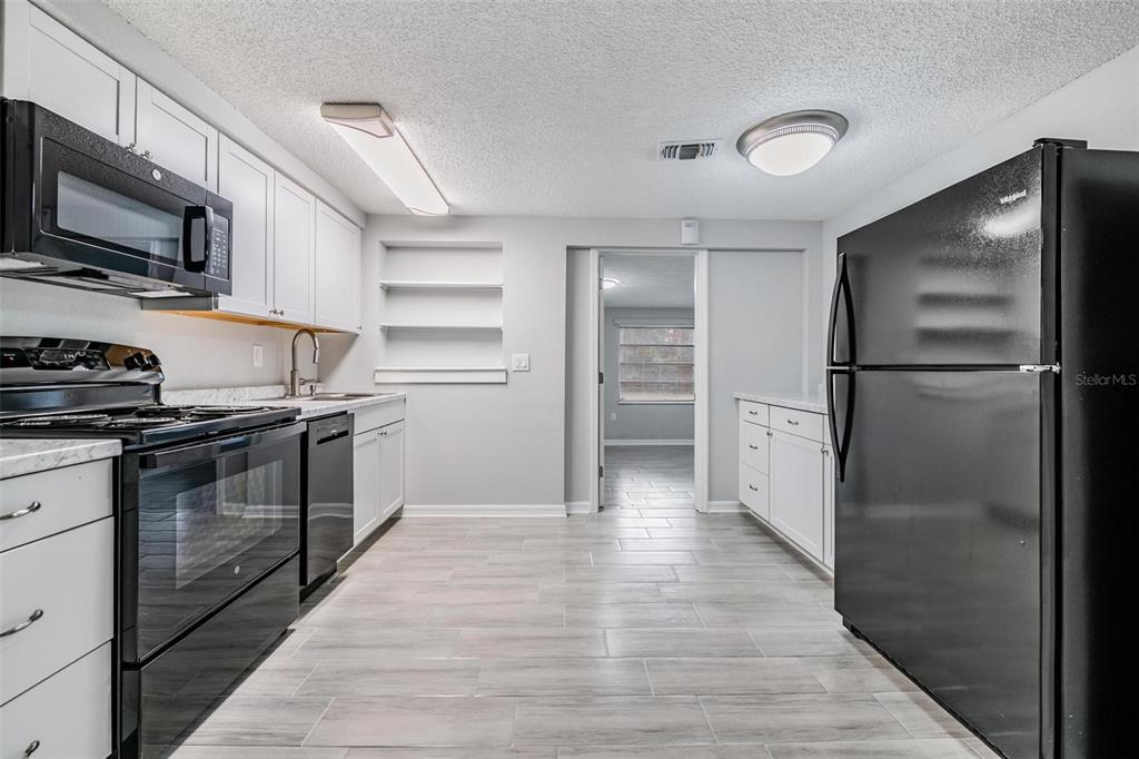 7806 Butler Avenue Hudson, FL 34667 - Photo 8 of 31 a kitchen with stainless steel appliances granite countertop a refrigerator and a stove top oven