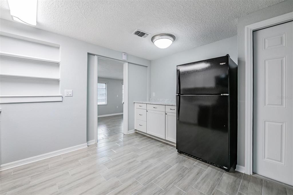 7806 Butler Avenue Hudson, FL 34667 - Photo 9 of 31 a view of empty room with wooden floor and cabinet