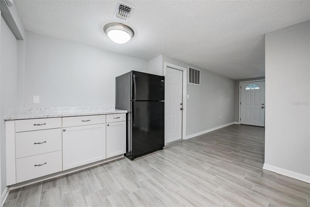 7806 Butler Avenue Hudson, FL 34667 - Photo 10 of 31 a view of kitchen with refrigerator cabinets and wooden floor