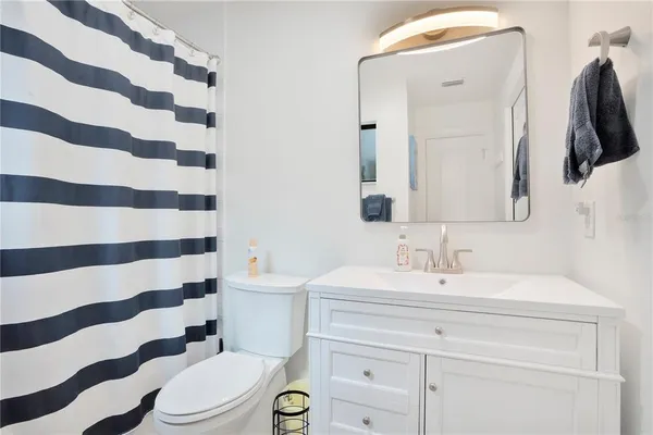 a bathroom with a sink a toilet a mirror and shower