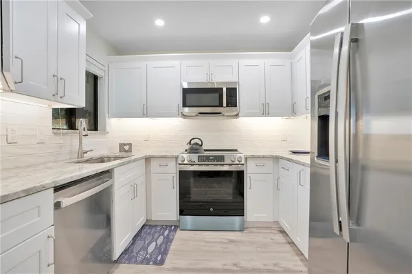 a kitchen with stainless steel appliances granite countertop a stove a refrigerator and a sink