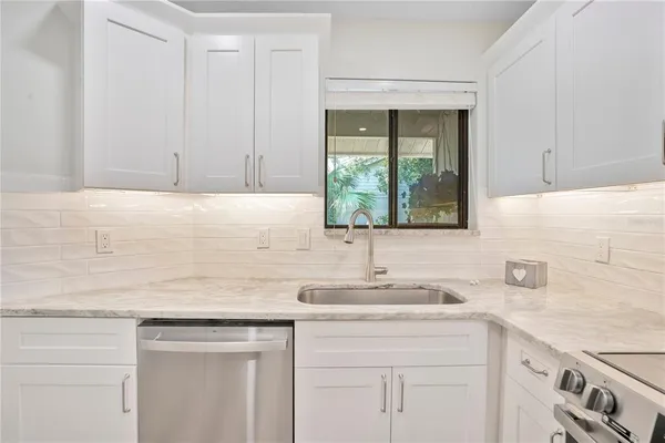 a kitchen with a sink cabinets and window