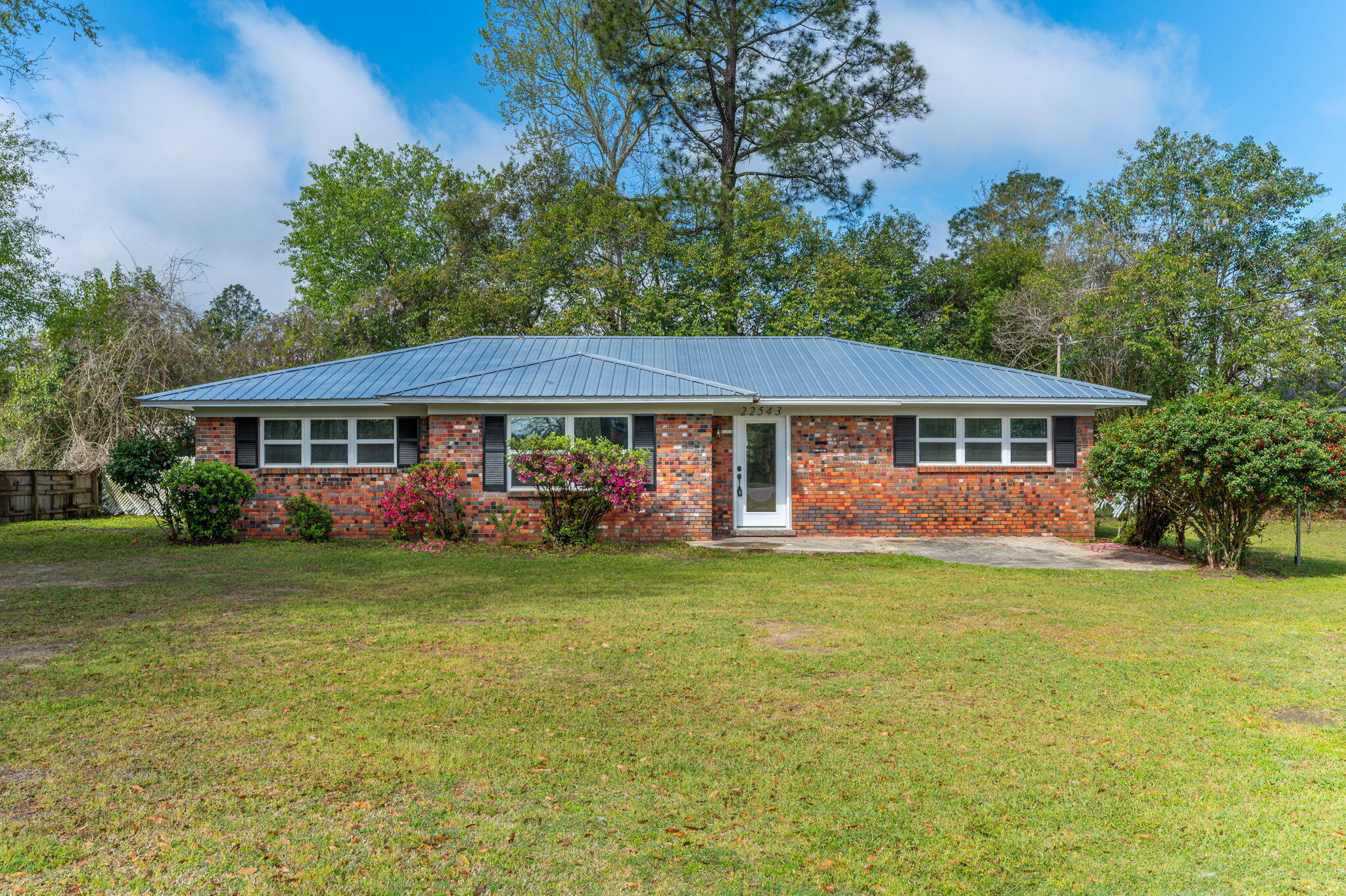 22543 Highway 331 Laurel Hill, FL 32567 - Photo 1 of 36 a front view of a house with a garden