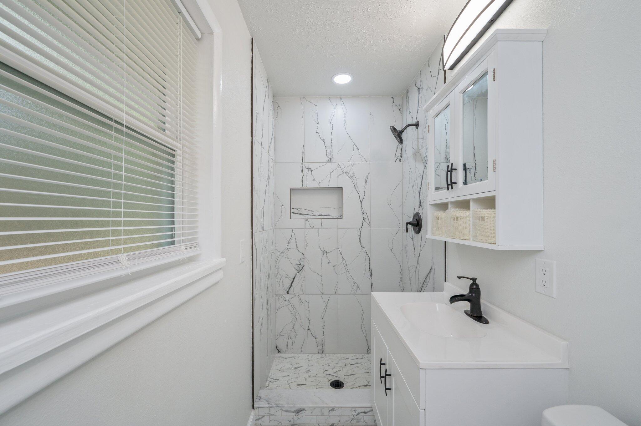22543 Highway 331 Laurel Hill, FL 32567 - Photo 20 of 36 a bathroom with a shower a sink and a mirror