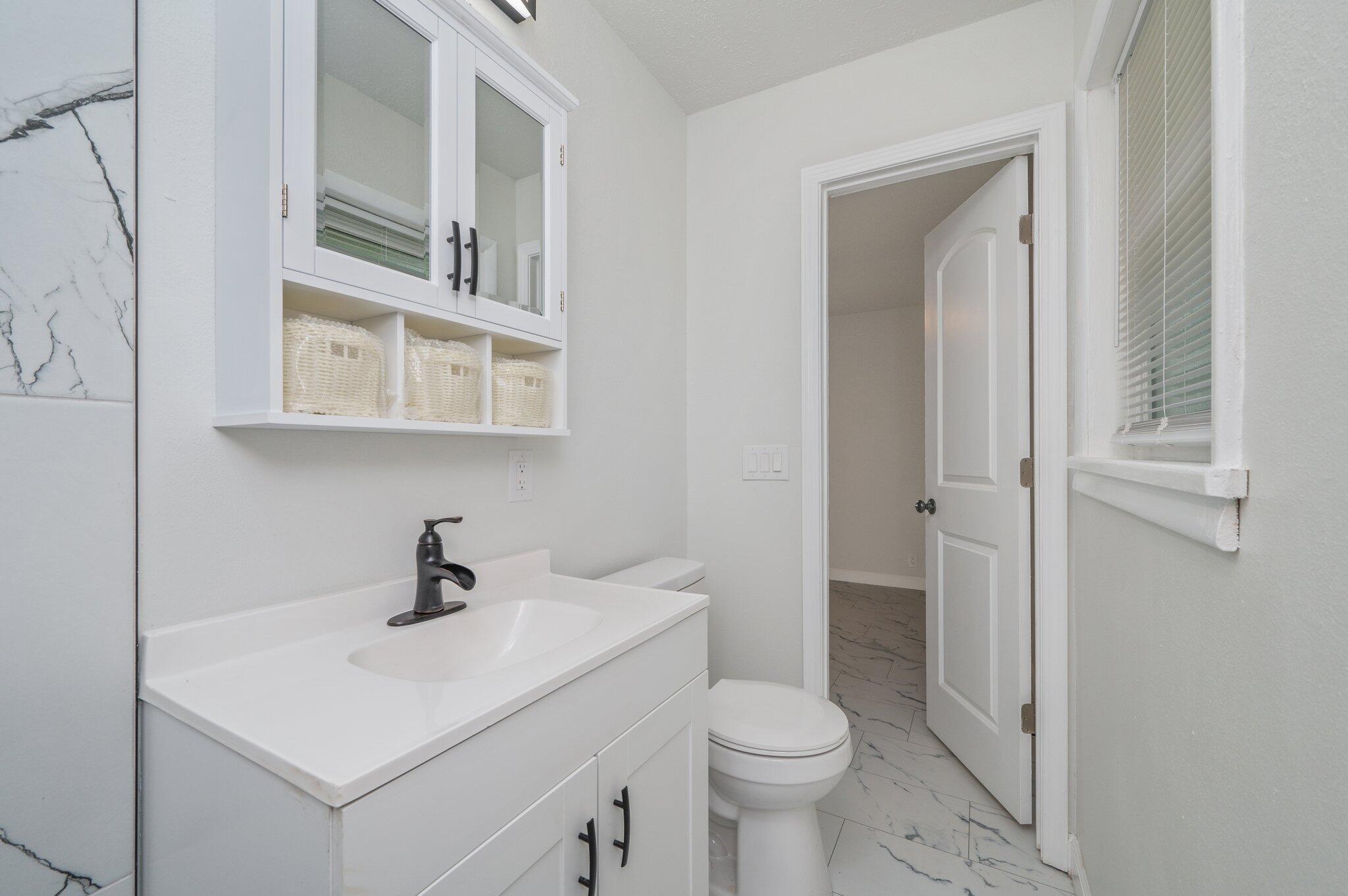 22543 Highway 331 Laurel Hill, FL 32567 - Photo 23 of 36 a bathroom with a toilet sink and mirror