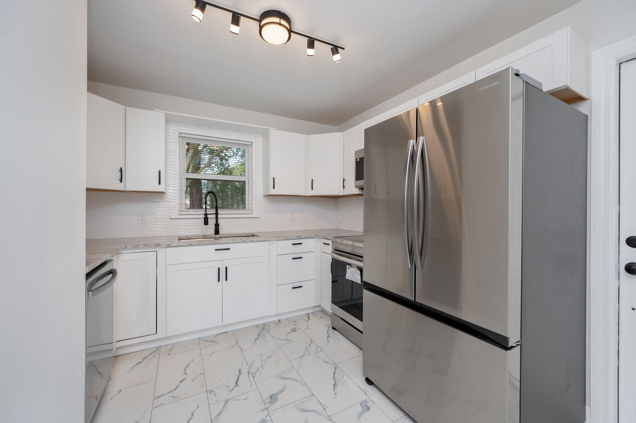 22543 Highway 331 Laurel Hill, FL 32567 - Photo 6 of 36 a kitchen with stainless steel appliances granite countertop a refrigerator sink and stove