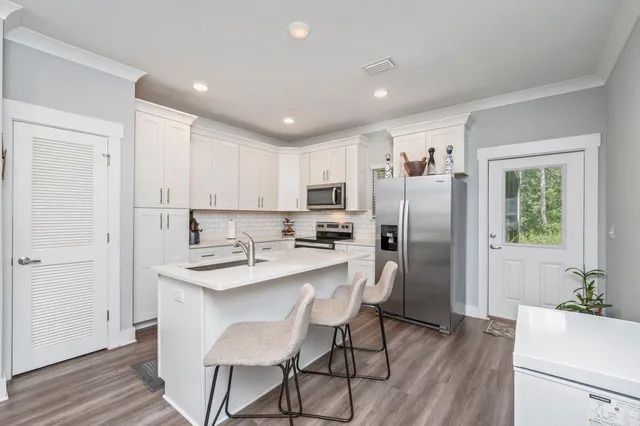 a kitchen with refrigerator cabinets and wooden floor