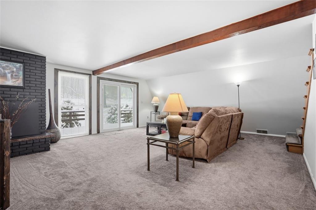 XL living room w/ exposed beam ceiling and sliding doors to deck!