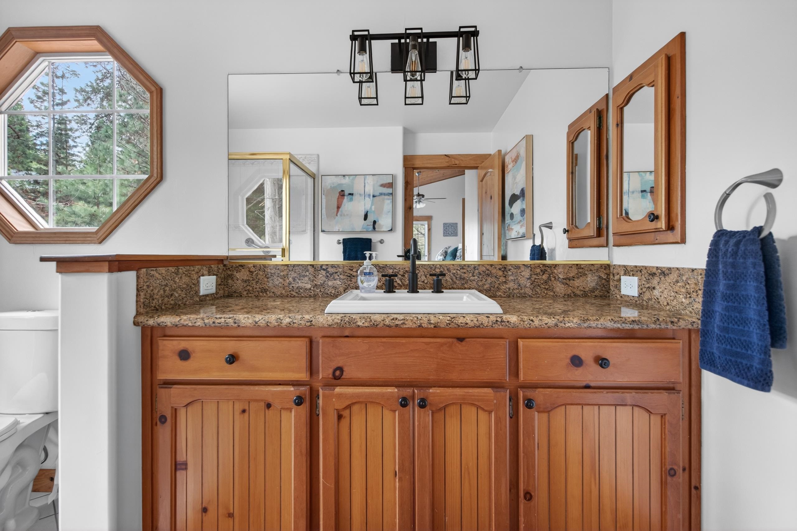 1220 Lynx Road Lake Almanor, CA 96137 - Photo 28 of 45 a bathroom with a granite countertop sink and a mirror