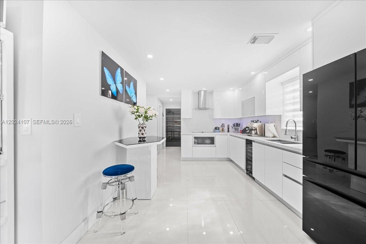 15341 Southwest 36th Street Miami, FL 33185 - Photo 11 of 56 a kitchen with white cabinets and stainless steel appliances