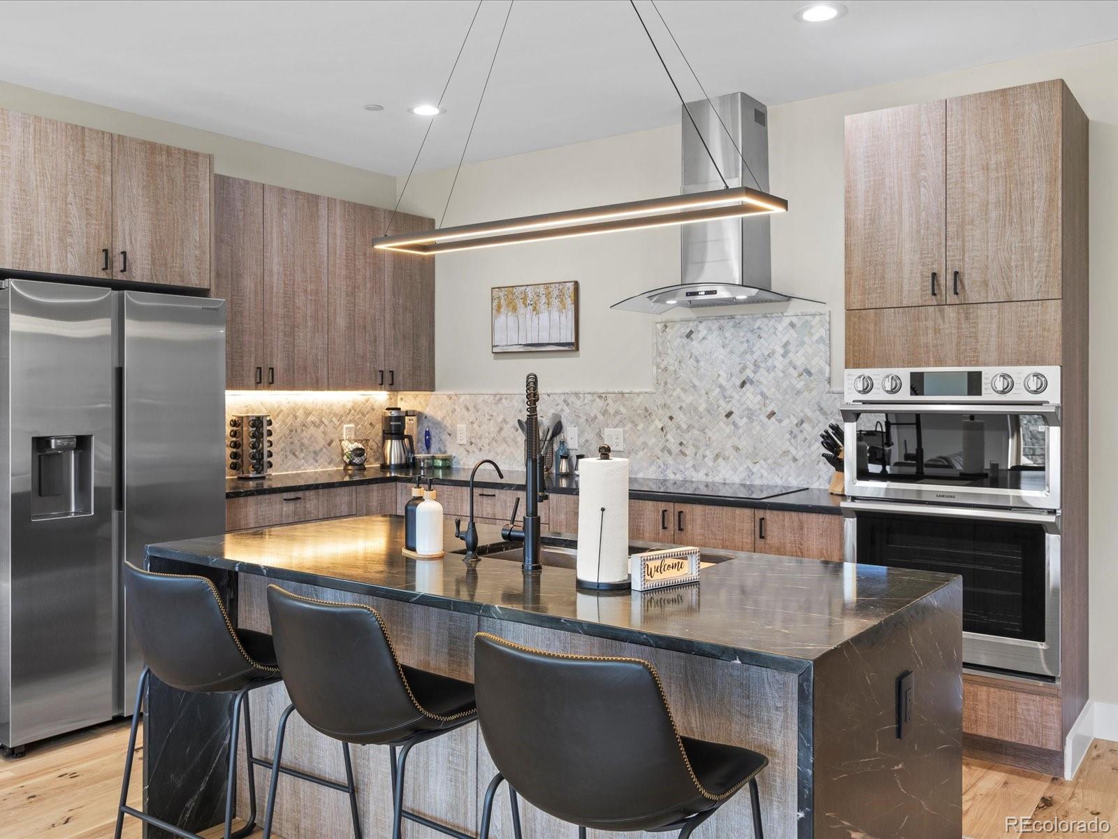 718 Emerson Gulch Road Boulder, CO 80302 - Photo 12 of 42 a kitchen with granite countertop a table chairs stove and refrigerator
