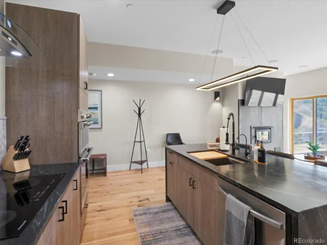 a kitchen with granite countertop a sink a stove and cabinets