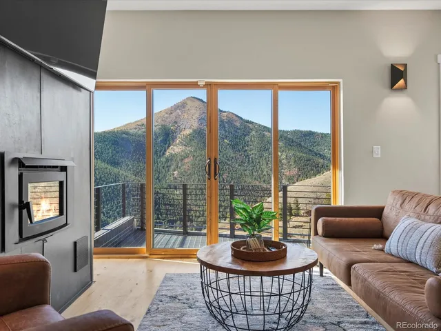 a living room with furniture a floor to ceiling window and a lamp