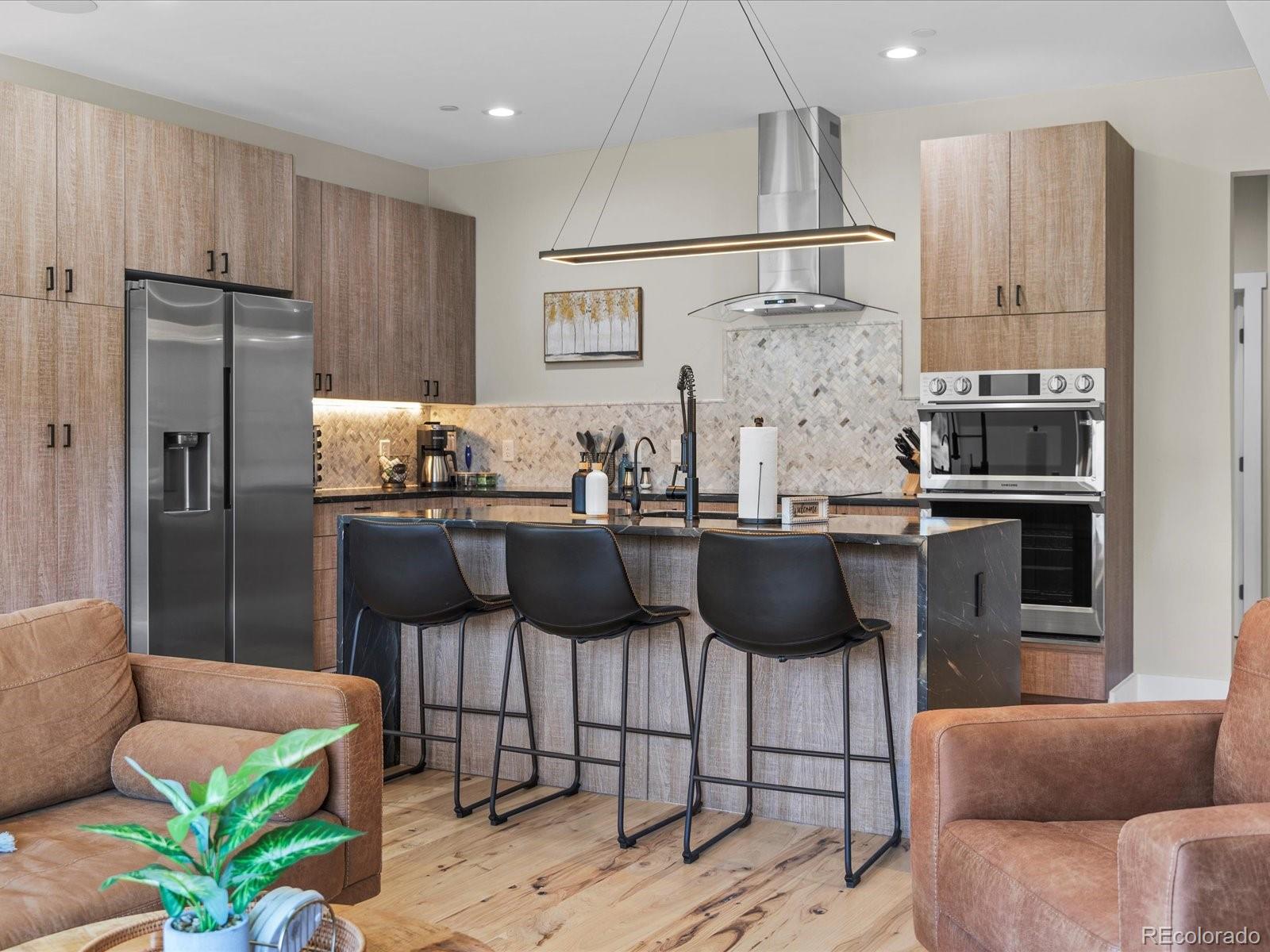 718 Emerson Gulch Road Boulder, CO 80302 - Photo 10 of 42 a kitchen with stainless steel appliances granite countertop a refrigerator a stove a sink a dining table and chairs