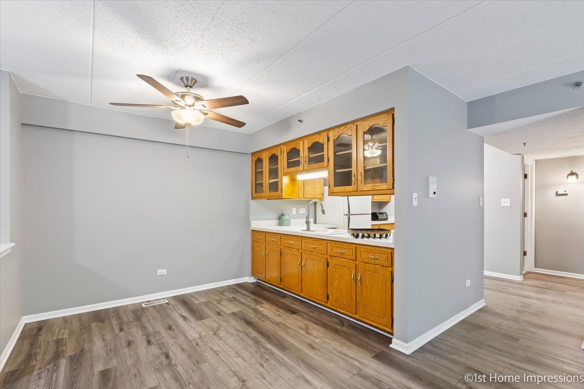 10626 Ridgeland Avenue, Unit 1B Chicago Ridge, IL 60415 - Photo 6 of 23 a view of a kitchen with wooden floor and a ceiling fan