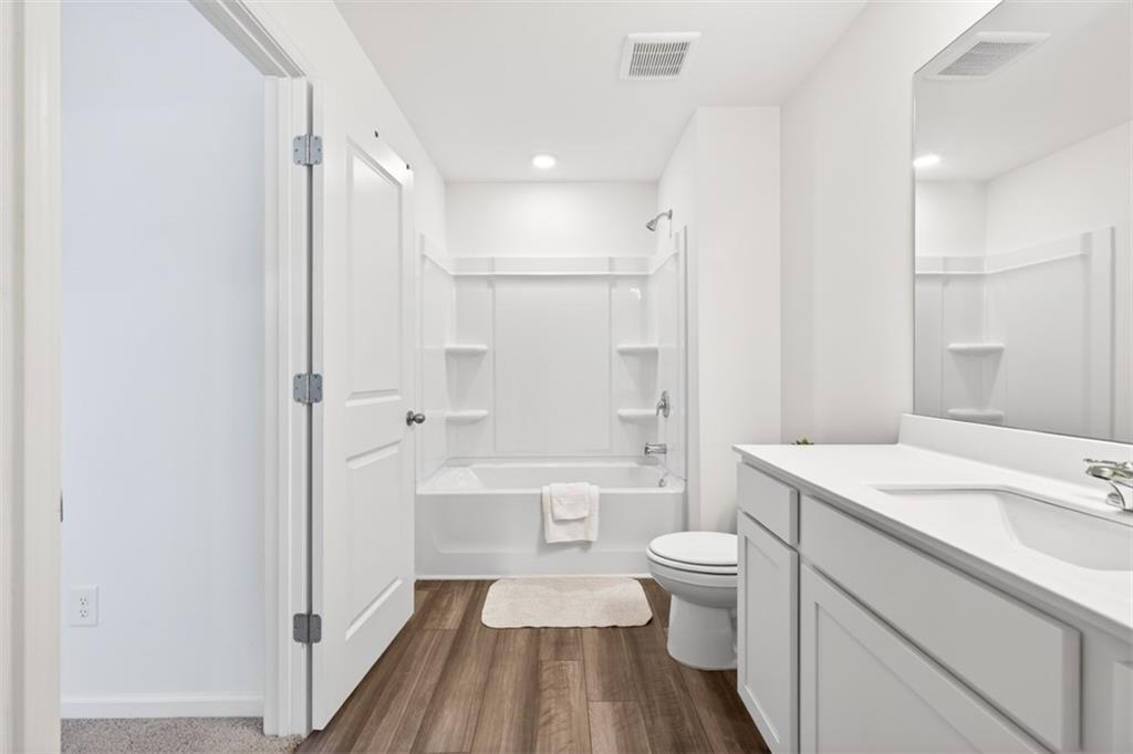 64 Thetford Way Winder, GA 30680 - Photo 19 of 41 a bathroom with a sink a toilet a mirror and shower