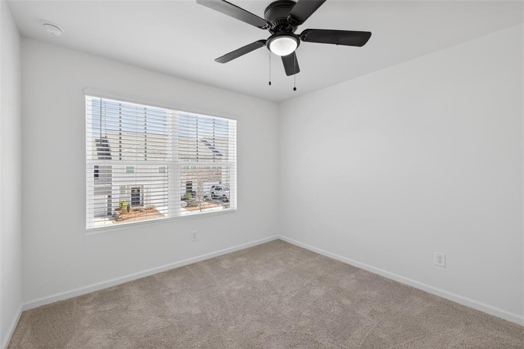 64 Thetford Way Winder, GA 30680 - Photo 22 of 41 an empty room with a window and a fan