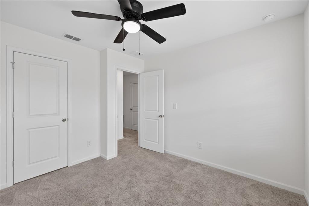 64 Thetford Way Winder, GA 30680 - Photo 23 of 41 an empty room with closet and a chandelier fan