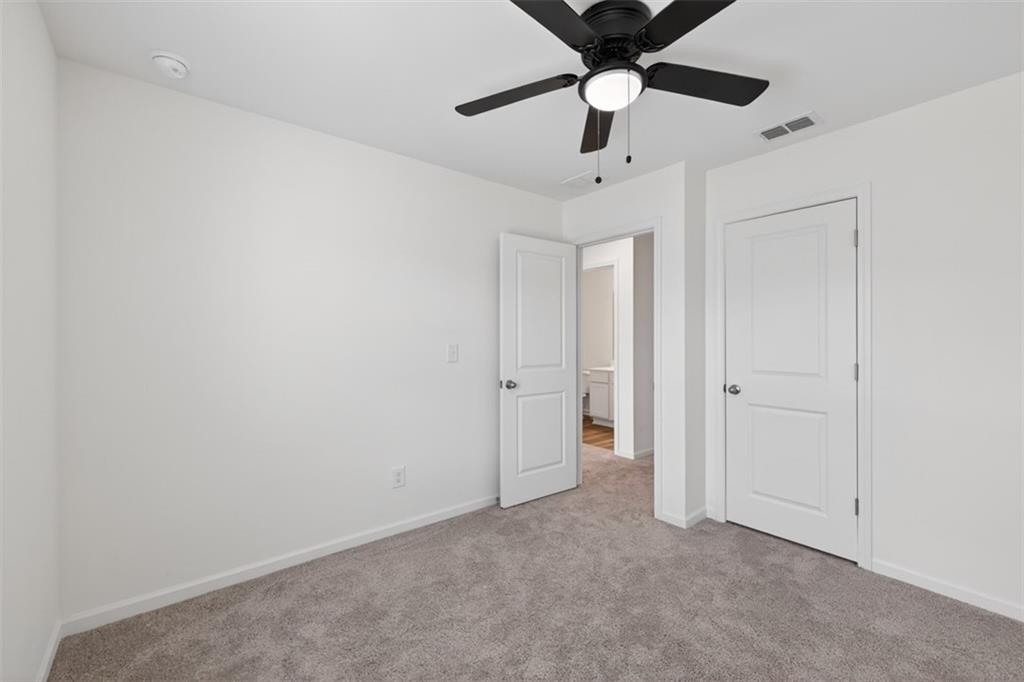 64 Thetford Way Winder, GA 30680 - Photo 28 of 41 an empty room with a hallway and a ceiling fan