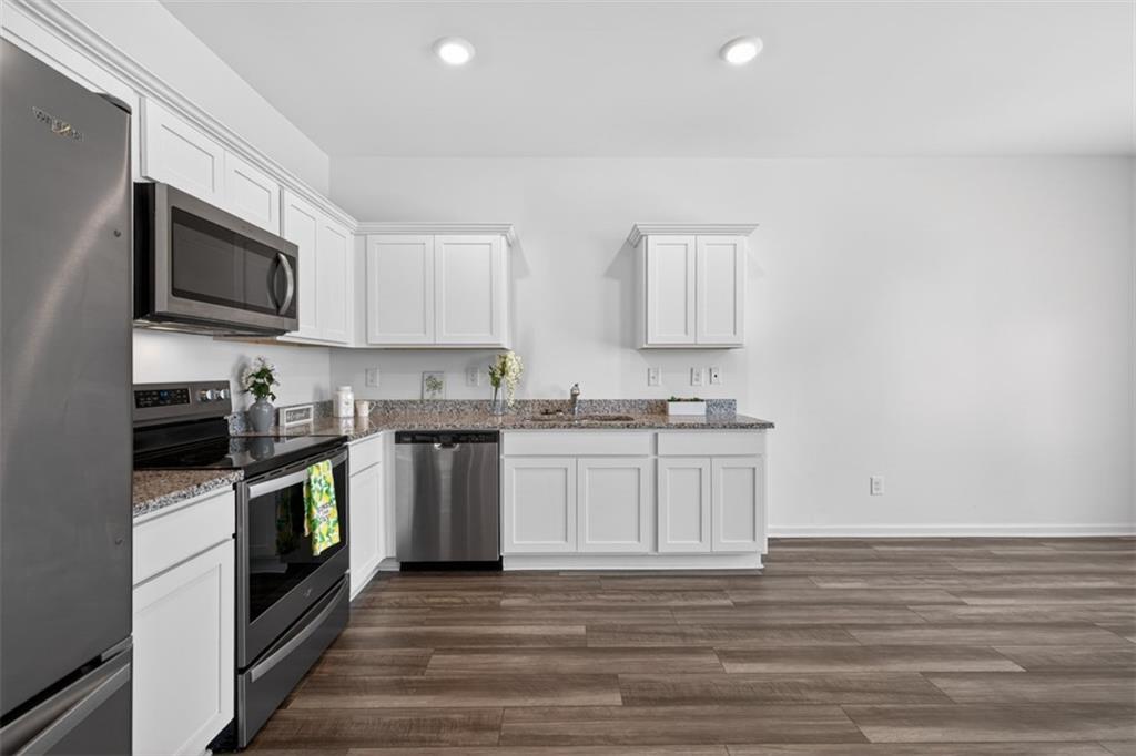 64 Thetford Way Winder, GA 30680 - Photo 8 of 41 a kitchen with stainless steel appliances granite countertop a stove a sink and a microwave