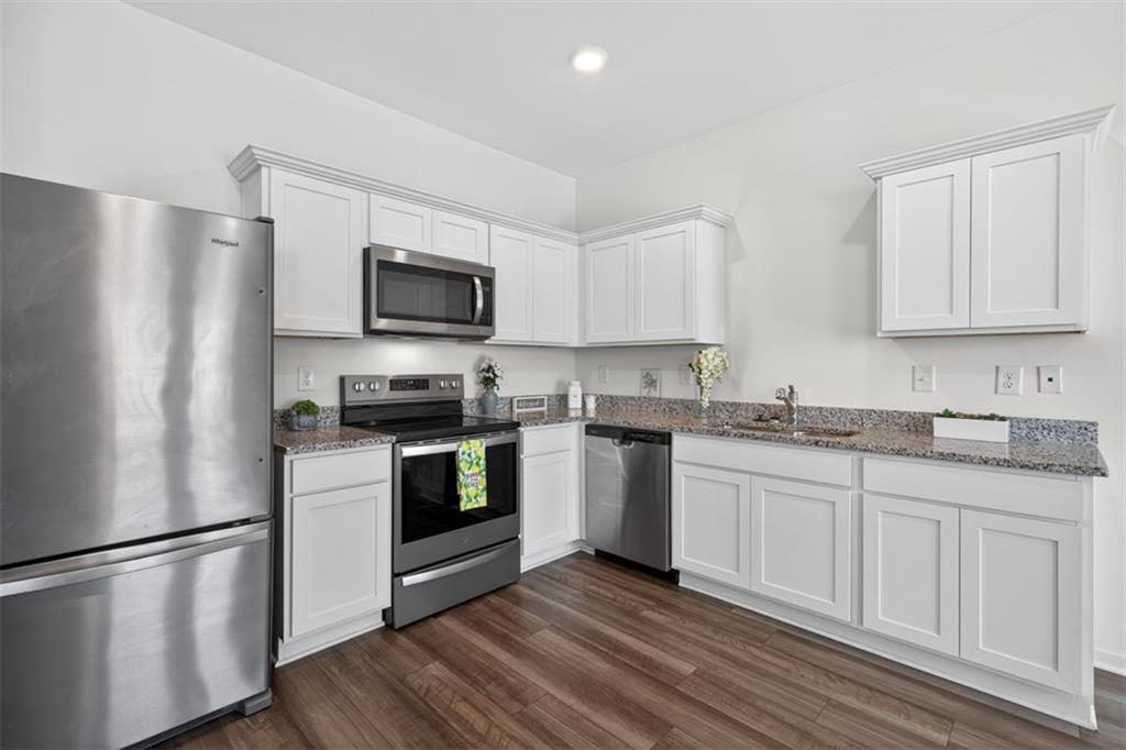 64 Thetford Way Winder, GA 30680 - Photo 10 of 41 a kitchen with granite countertop a refrigerator stove top oven and sink