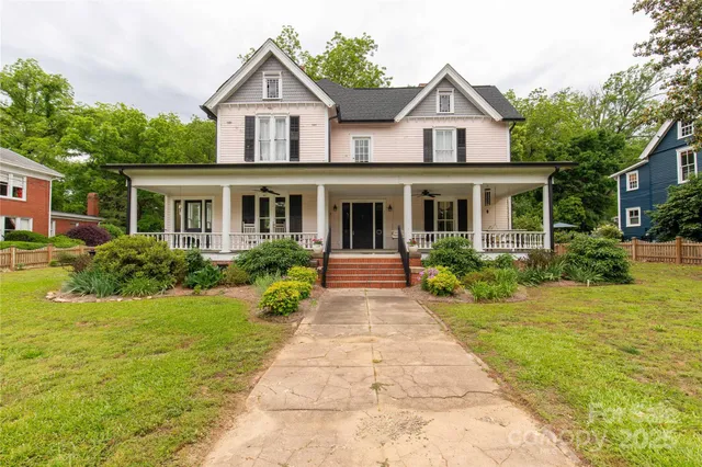 a front view of a house with a yard and potted plants