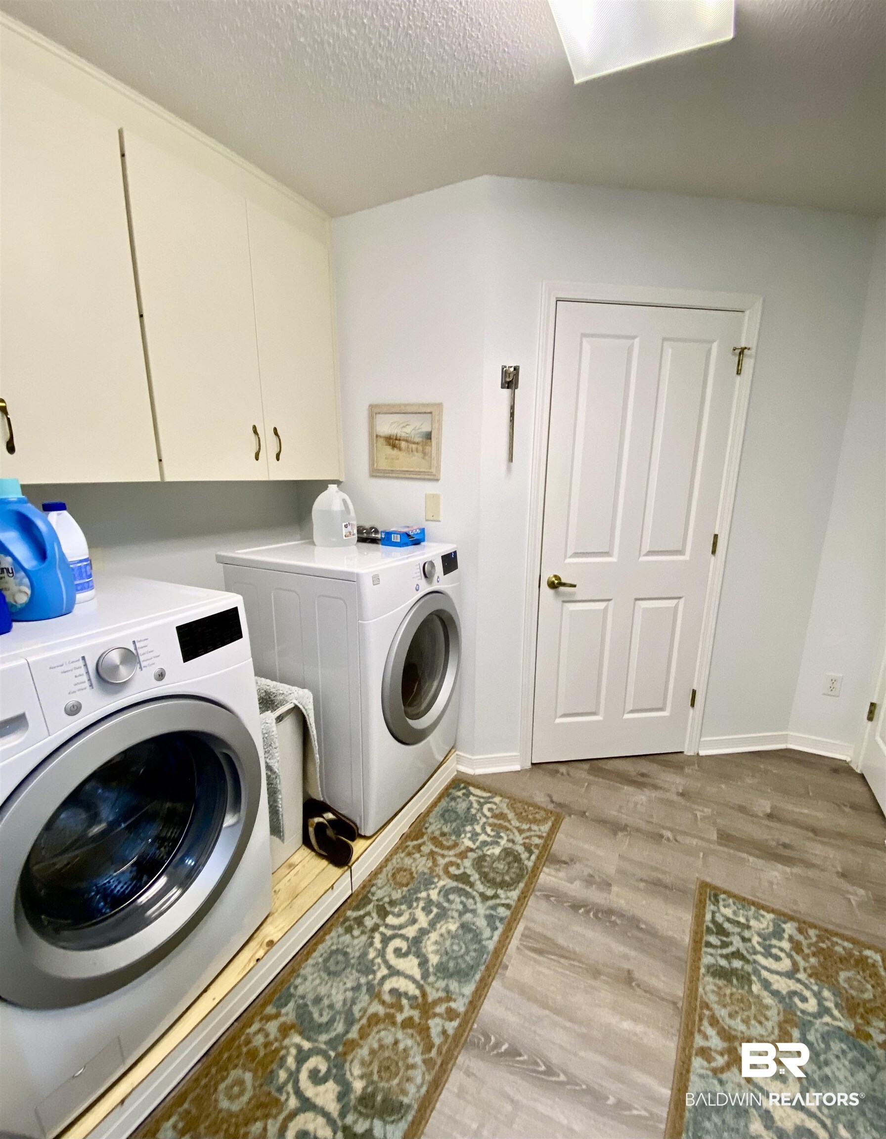 2872 Avenida Alberto Lillian, AL 36549 - Photo 25 of 31 Laundry area with cabinets, independent washer and dryer, light wood-type flooring, and a textured ceiling