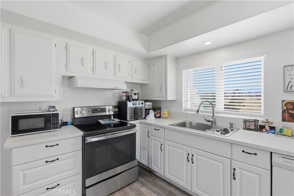 5885 Dos Palmas Road Phelan, CA 92371 - Photo 11 of 40 a kitchen with cabinets appliances a sink and a window