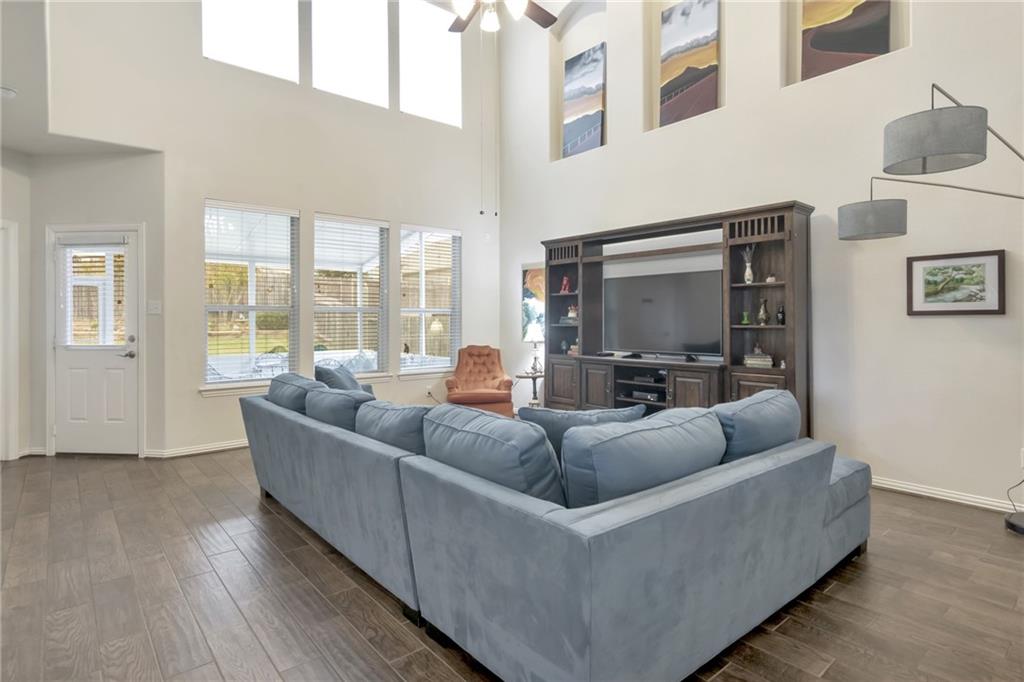 252 Pond View Pass Buda, TX 78610 - Photo 13 of 37 Living room featuring dark wood finished floors, plenty of natural light, a ceiling fan, and a towering ceiling