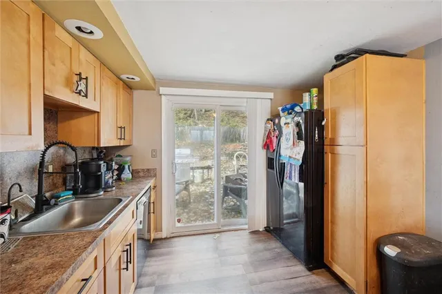 a kitchen with refrigerator a sink and a large window